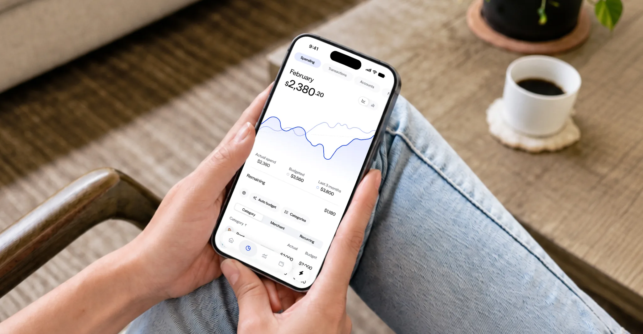 A person holding a phone showing their monthly spending in the Albert app